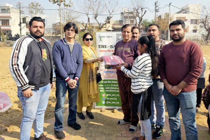 Members of NGO ‘THE - SARA’ distributing woolen sweaters to underprivileged children in Sainik Colony.