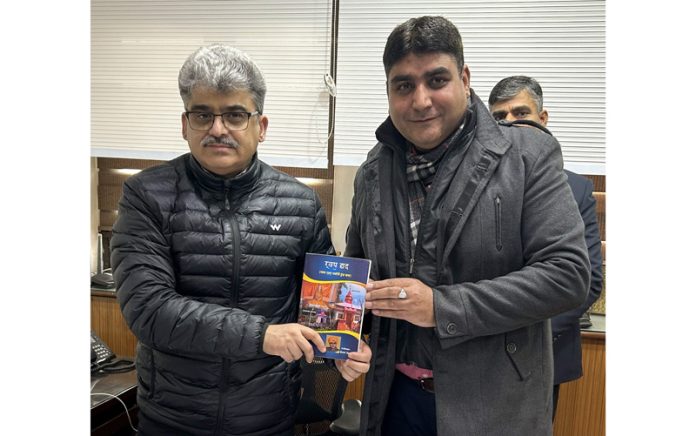Chief Secretary Atal Dulloo receiving a book from Kanwal Peshin, a distinguished poet, writer and cultural activist.