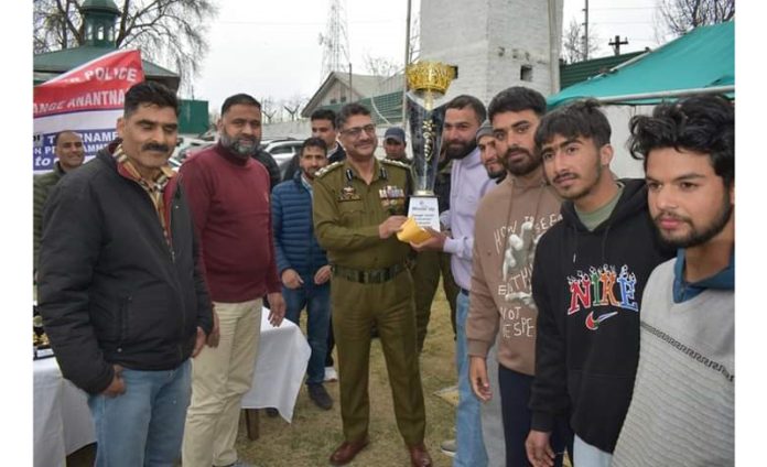 Senior police officer presenting trophy to winning team at Anantnag.