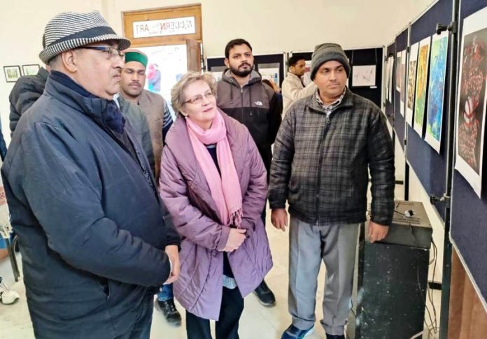 Art lovers looking at a painting exhibited in international art exhibition 'Exoressions-24' at Kullu (HP).