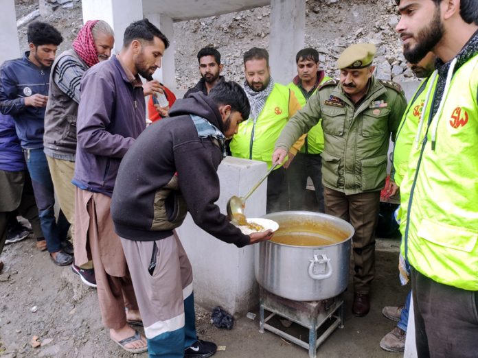 Police provides food to stranded passengers in Ramban area on Sunday. -Excelsior/Parvaiz Mir
