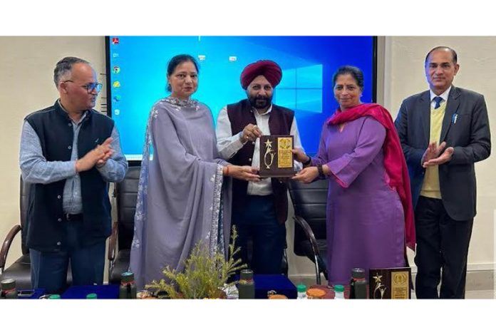 Director Ayush J&K/CEO JKMPB, Dr Mohan Singh presenting a memento to a guest during a programme.