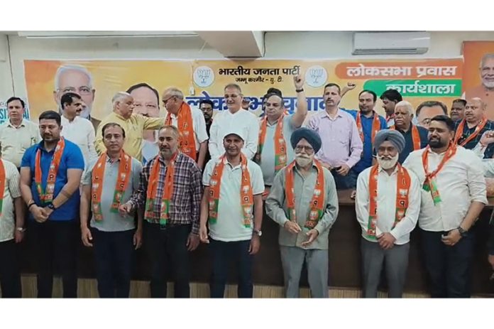 Senior BJP leaders, Ashok Koul and Kavinder Gupta taking senior Congress leader, Harbans Bral and his supporters in party fold after joining the BJP on Thursday at Jammu.