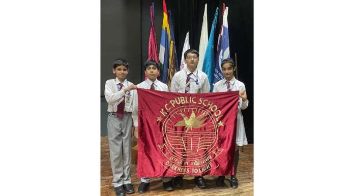 Students of KCPS posing by holding school flag.