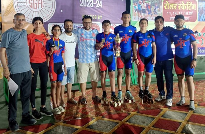 J&K Skaters posing along with their Manager, medals and trophy.