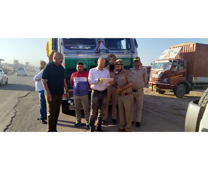 An officer of State Taxes Department scrutinizing bills of goods loaded in a truck at Samba. An officer of State Taxes Department scrutinizing bills of goods loaded in a truck at Samba.