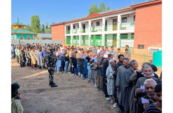Voters waiting in queue to cast their votes at Pattan in Baramulla district. -Excelsior/Abid Nabi