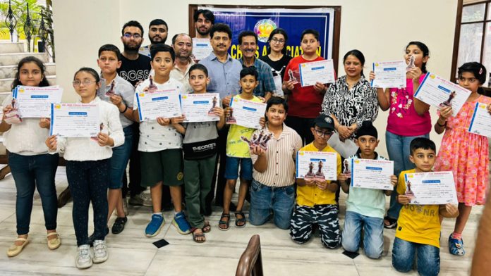 Chess players displaying certificates while posing along with dignitaries.
