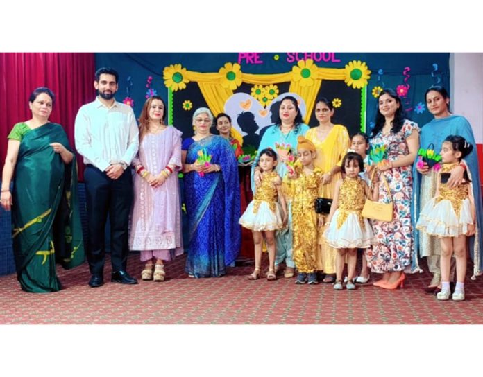 School management posing along with teachers and students during a programme.  