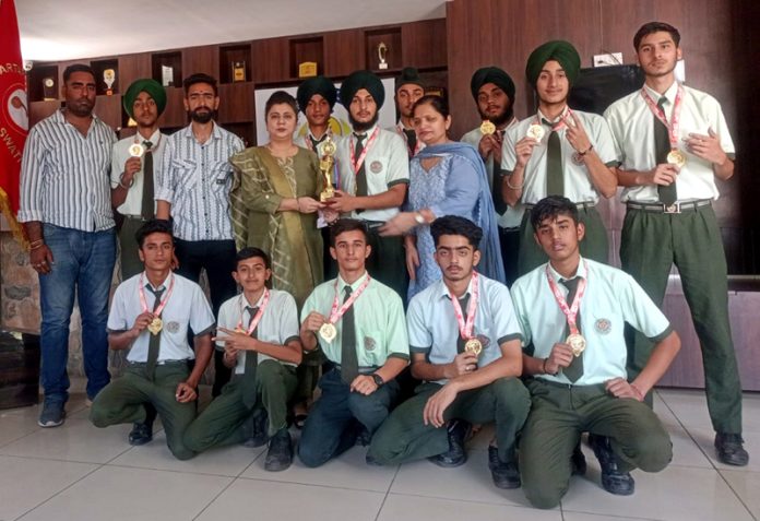 KPS team displaying medals & a trophy while posing with school management.