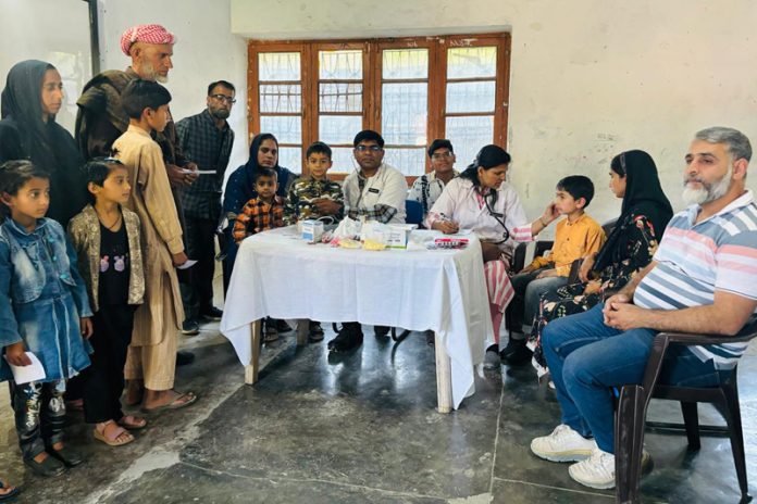 Doctors examining patients during a medical camp at Thanamandi (Rajouri) on Monday.