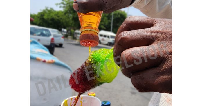A vendor prepares an ice candy on a hot summer day in Jammu. -Excelsior/Rakesh