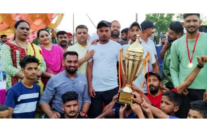 Winning team posing along with trophy.