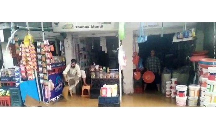 Rain and flooded drain water enters shops in Thannamandi market in Rajouri district. -Excelsior/Imran