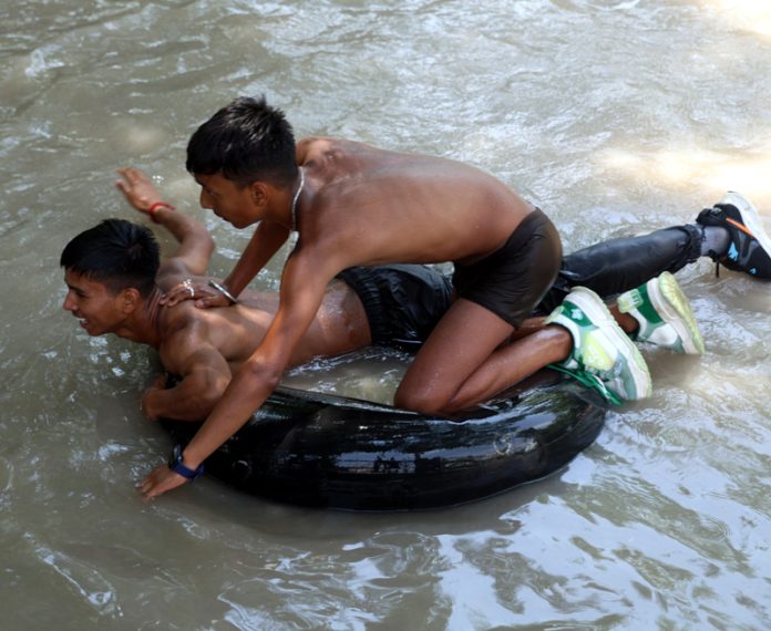 Boys take bath in a canal to beat the heat in Jammu on Wednesday. -Excelsior/Rakesh