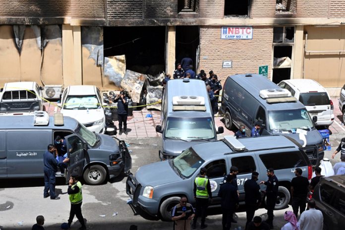Staff members work at the site of a fire in Mangaf, Ahmadi Governorate, Kuwait on Wednesday. (UNI)