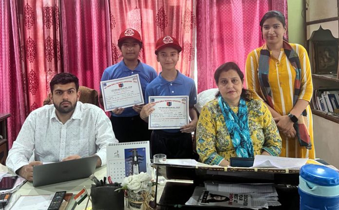 Dewan Devi Public School students displaying certificates while posing with school management.