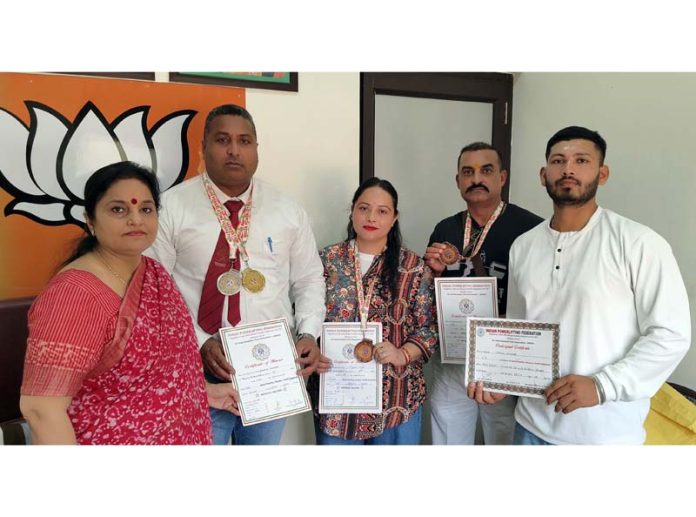 Priya Sethi, former Minister posing along with medal winner powerlifters at BJP headquarters in Jammu.