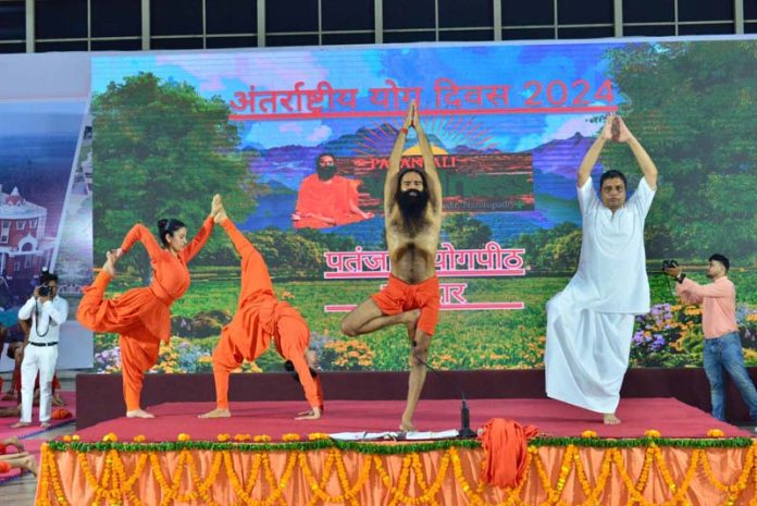 Yoga Rishi, Swami Ramdev and Acharya Balkrishan performing Yoga exercises at Haridwar on International Yoga Day.