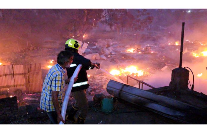 Firefighters making efforts to contain a devastating fire at Jammu Railway Station on Sunday. -Excelsior/Rakesh