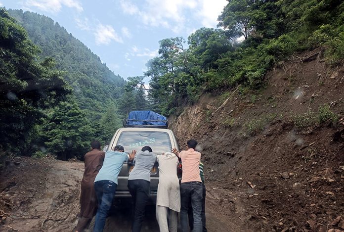 Passengers pusing a vehicle on slippery Thannamandi - DKG Road in Rajouri. -Excelsior/Imran Passengers pusing a vehicle on slippery Thannamandi - DKG Road in Rajouri. -Excelsior/Imran