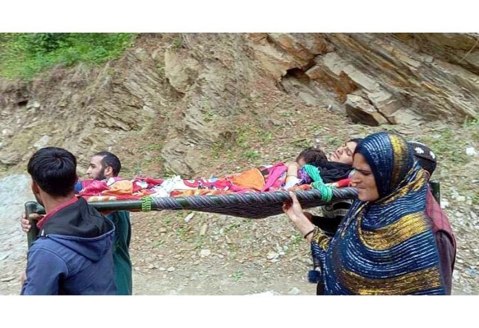 A patient being carried on shoulders to hospital in Tanta Draman area of Doda. -Excelsior/Rafi Choudhary