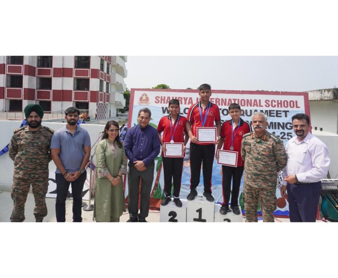 Students posing with dignitaries and certificates on the podium at Shaurya International School's Inter-House Aqua Meet.