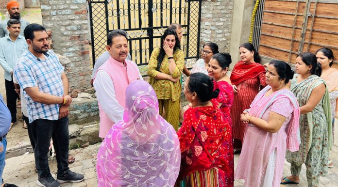 Former Dy Mayor, Baldev Singh Billawaria talking to local people after kick starting construction of lane and drain in Gangyal on Saturday.