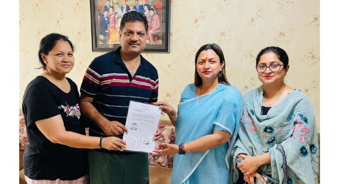 BJP leader Rekha Mahajan presenting domicile certificate to a person in Jammu South area.