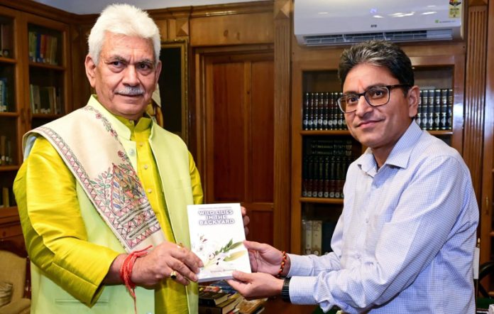 Lt Governor Manoj Sinha being presented a book by Vishal Sharma. Lt Governor Manoj Sinha being presented a book by Vishal Sharma.