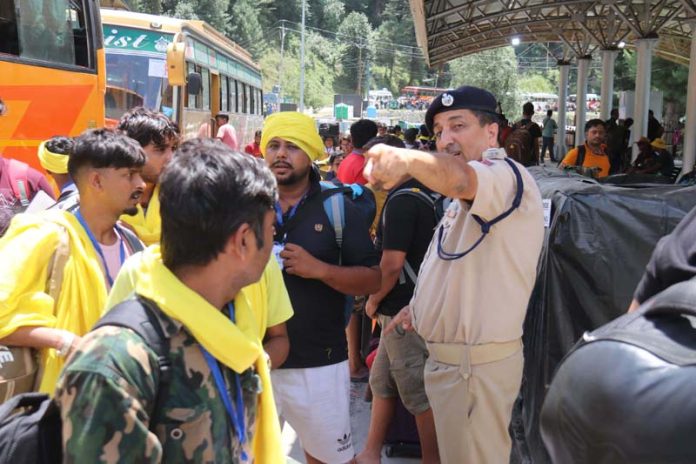 A police officer guiding the Amarnath bound pilgrims at Nunwan Base Camp on Wednesday. A police officer guiding the Amarnath bound pilgrims at Nunwan Base Camp on Wednesday.