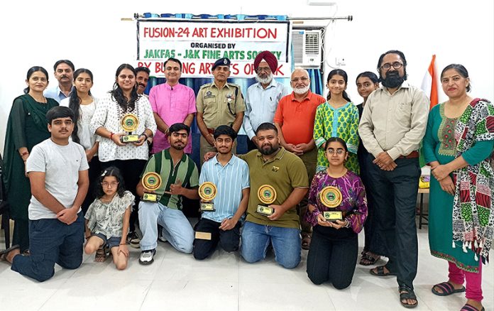 Artists along with others posing for a group photograph at an exhibition in Jammu on Sunday.