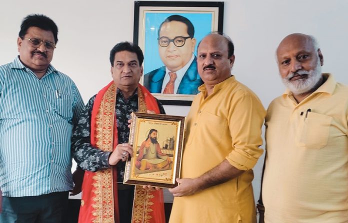 Balbir Ram Rattan, BJP senior leader presenting a portrait of Guru Ravi Dass Ji to BJP general secretary, Dr D K Manyal at Jammu on Friday.