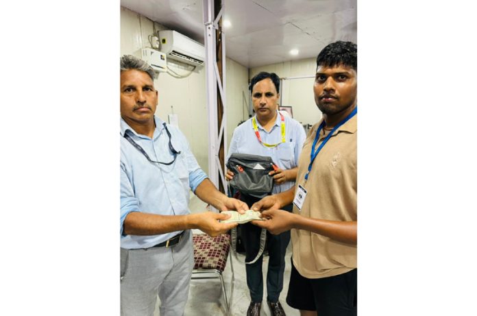 Bag being returned to Shri Amarnath Ji pilgrim while the cop gets award. Bag being returned to Shri Amarnath Ji pilgrim while the cop gets award.