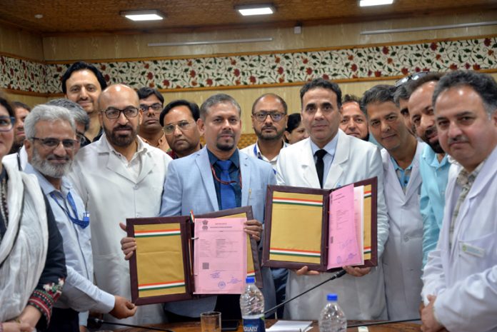 Director SKIMS and Director CCRUM display copy of MoU.