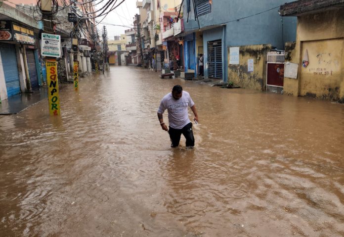 A man moving through knee-deep water in a lane at Nanak Nagar after heavy rain in Jammu on Wednesday. -Excelsior/Rakesh A man moving through knee-deep water in a lane at Nanak Nagar after heavy rain in Jammu on Wednesday. -Excelsior/Rakesh