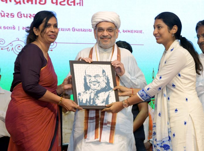 Union Home Minister Amit Shah hands over the citizenship certificate under the CAA to a beneficiary during a programme in Ahmedabad on Sunday. (UNI)