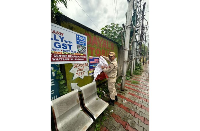 Flying Squad personnel removing posters from walls on Wednesday.