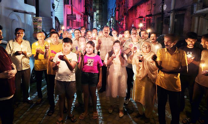 Residents of Panjtirthi area during a candle light protest on Friday. Residents of Panjtirthi area during a candle light protest on Friday.