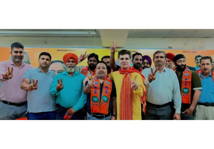 Kasim Choudhary who along with supporters joined BJP at a function posing with BJP UT president, Ravinder Raina at Jammu on Sunday.