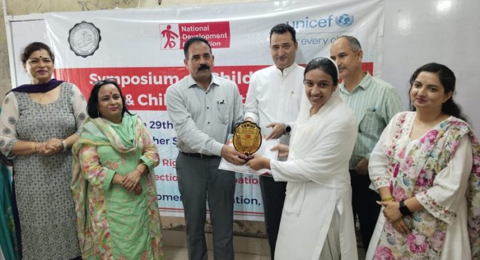 CEO Jammu presenting award to winner of symposium.