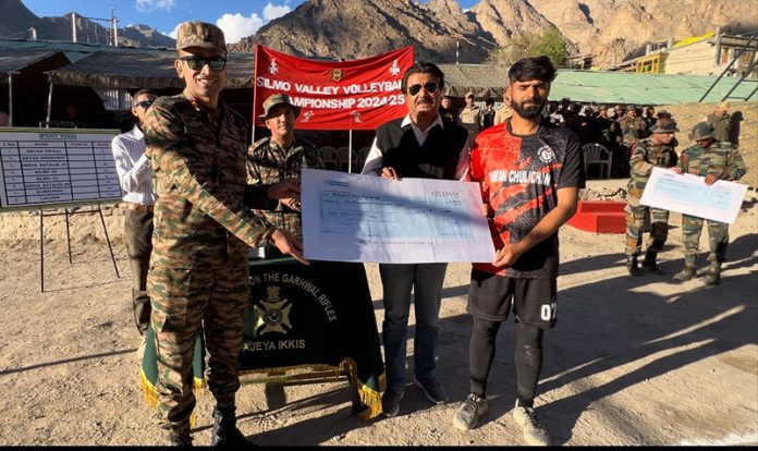 Army officer, dignitary presenting cheque to winning team captain. Army officer, dignitary presenting cheque to winning team captain.