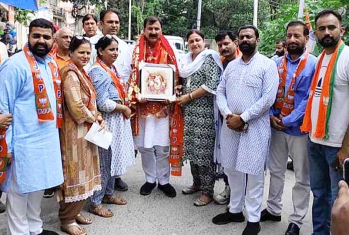 Senior BJP leader, Arvind Gupta receiving a framed photo of Lord Ganesha from a supporter during election campaigning. Senior BJP leader, Arvind Gupta receiving a framed photo of Lord Ganesha from a supporter during election campaigning.
