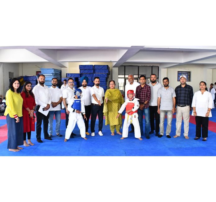 Taekwondo players posing along with dignitaries during a championship.
