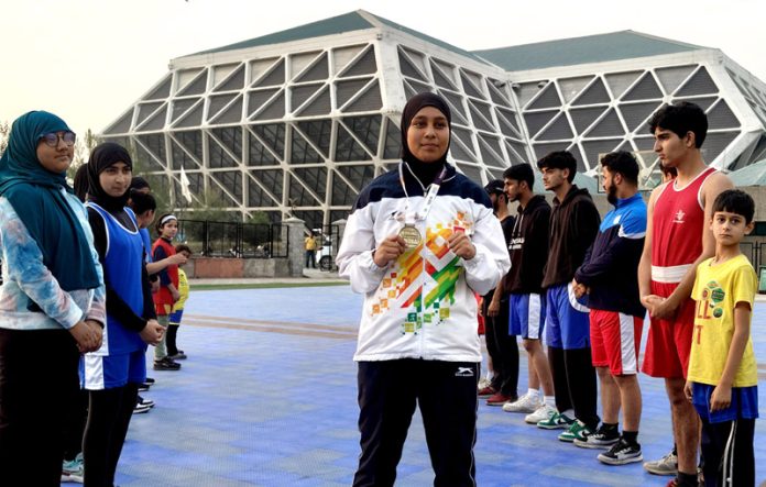 Bareena posing with her gold medal at Indoor Stadium in Srinagar on Monday. -Excelsior/Shakeel Bareena posing with her gold medal at Indoor Stadium in Srinagar on Monday. -Excelsior/Shakeel