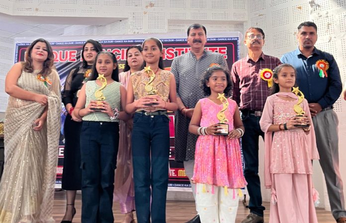 Students displaying trophies while posing with dignitaries during an event. Students displaying trophies while posing with dignitaries during an event.