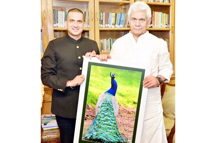 Lt Governor Manoj Sinha being presented with the pictorial art-work “Pride of Peacock is Glory of India” by Harpreet Sandhu.