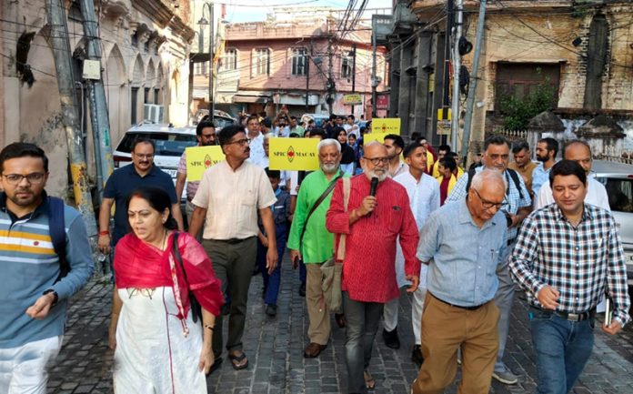 Dignitaries from SPIC MACAY's J&K chapter and students passing through the historic Raghunath Bazar during the heritage walk on Sunday.