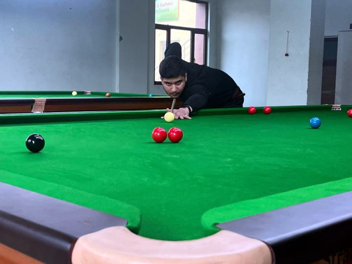 A snooker player in action during a match at Srinagar.