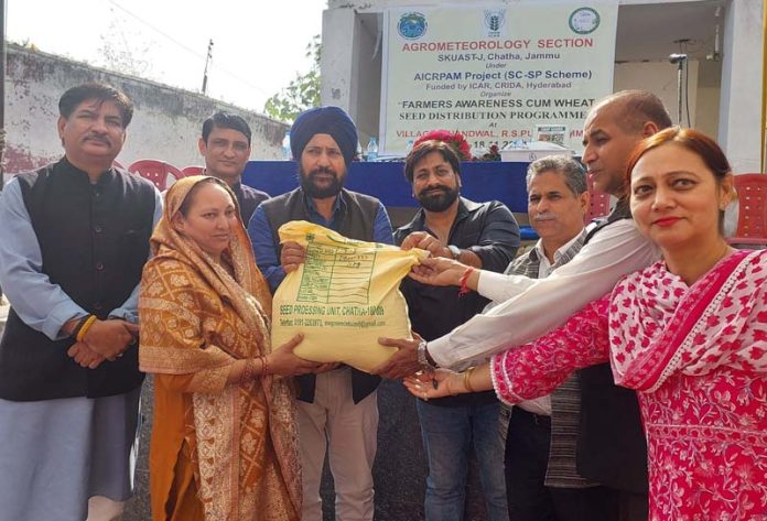 Dr Narinder Singh along with others distributing wheat seed variety. Dr Narinder Singh along with others distributing wheat seed variety.